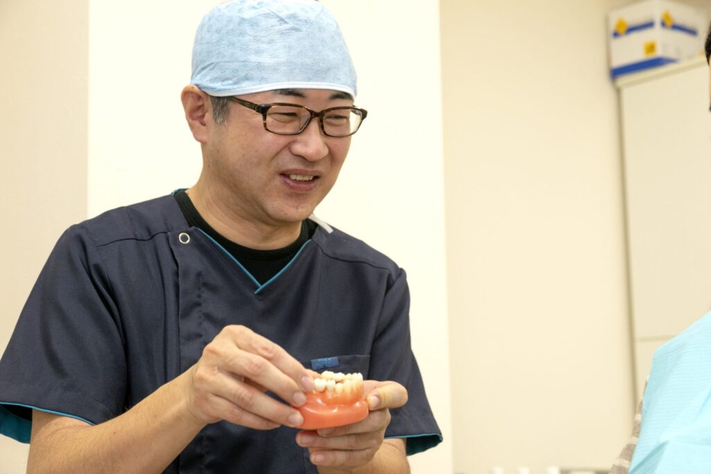みやざき歯科の院長が歯の模型を使って説明している様子
